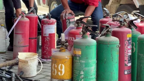 A technician is checking and repairing a fire extinguisher Stock Footage 296140548