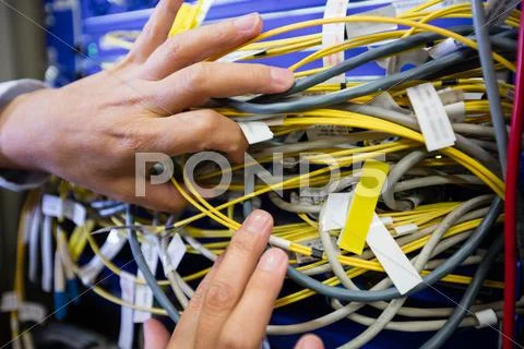 Technician Checking Cables In A Rack Mounted Server