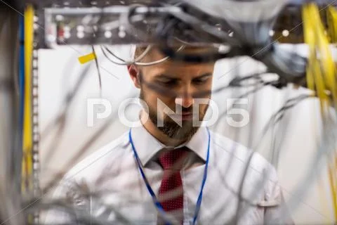 Technician Checking Cables In A Rack Mounted Server