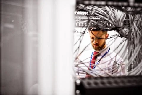 Technician checking cables in a rack mounted server Stock Photos