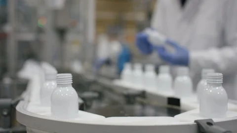 Technician checking cosmetic bottles on production line in factory Stock Footage 107973204