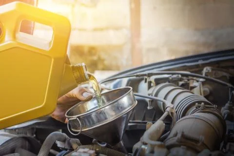 Technician checking engine and refueling. Auto mechanic checking car engine.  Stock Photos