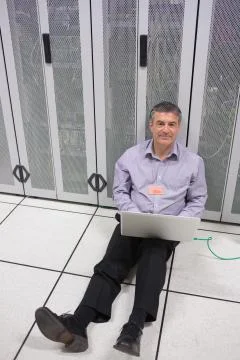 Technician checking the servers on the floor Stock Photos