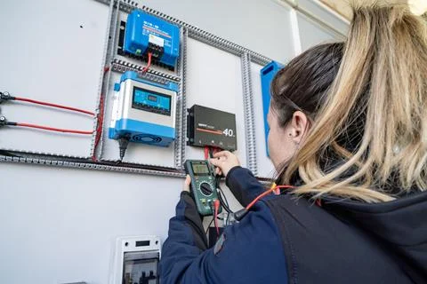 Technician checking solar charge controller on electrical panel Foto stock