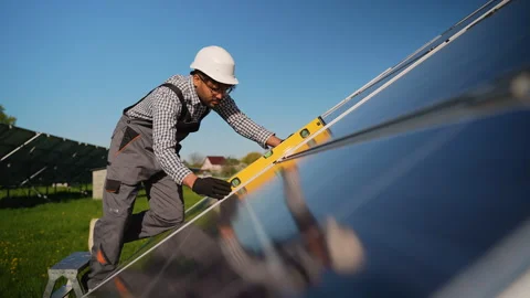 Technician checking solar panel angle with spirit level Stock Footage 314403447