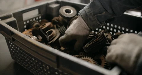 Technician is choosing the gears to take from a box at his workshop, tech stuff Stock Footage 152735697