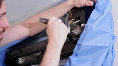 Technician cleaning air conditioner coils with brush Stock Footage 338008562