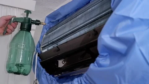 Technician cleaning air conditioner with pressure sprayer Stock-Footage 338008573