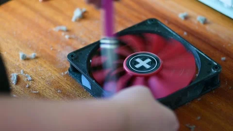 Technician cleaning a computer cooling fan on a wooden table slow motion Stock Footage 347437274