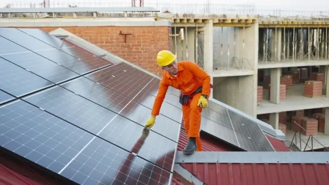 Technician cleaning solar panels on a rooftop Stock Footage 343894658