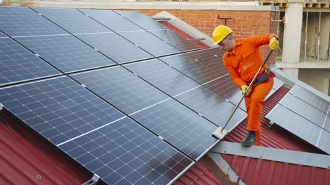 Technician cleaning solar panels on a rooftop Video stock 343894699