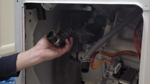 A technician cleaning a washing machine drain pip Stock Footage 330080901
