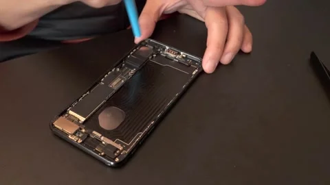 Technician cleans dust off while repairing cellular phone - 4K Stock Footage 295004500