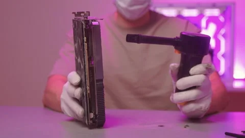 Technician cleans hardware. Worker sanitizes computer parts using compressed air Stock Footage 347877583