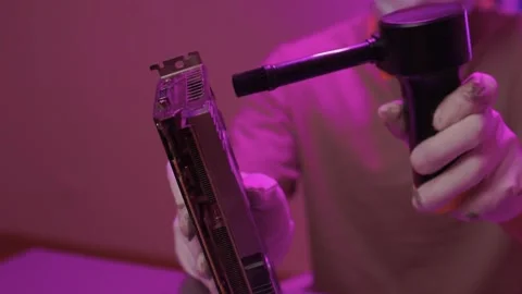 Technician cleans hardware. Worker sanitizes computer parts using compressed air Stock Footage 347877599