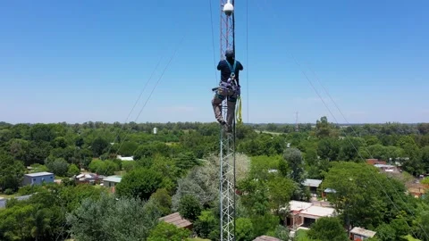 Technician Climbing Communications Tower with Safety Gear in Suburban Outdoor Stock Footage 337664846