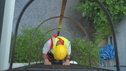 Technician climbs down a ladder to the rooftop to check the installation Stock Footage 282757159
