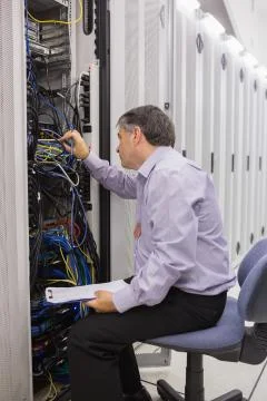 Technician with a clipboard checking servers Stock Photos