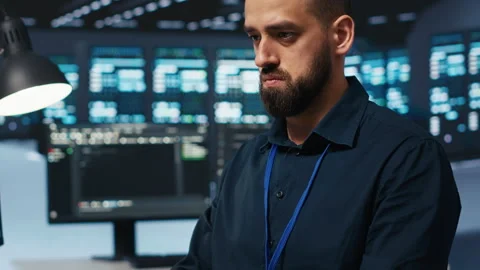 Technician coding in high tech facility with server rows, close up shot Stock Footage 275490714