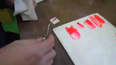 Technician comparing a small red paint sample against a card of reference Stock Footage 347123937