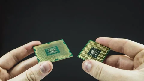 Technician comparing two microchips on black background Stock Footage 295184495