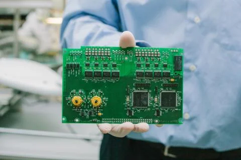 Technician with computer circuit board with chips. Spare parts and components Stock Photos