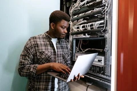 Technician configuring server settings in a data center during the day Stock Photos