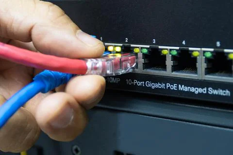 Technician connect cable network to switch port in server room Foto stock