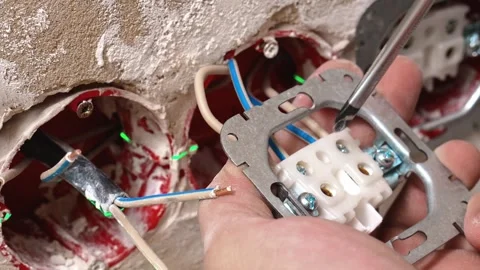 Technician Connecting Cables And Securing Terminals In Wall Pathway Stock Footage 329106345