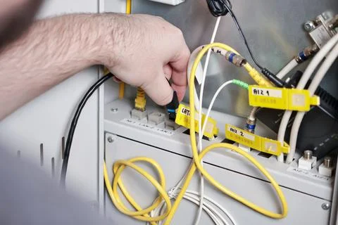 Technician connecting network cables in server panel, internet and communic.. Stock Photos