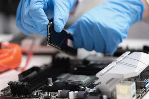 Technician connects CPU microprocessor to motherboard socket 写真素材
