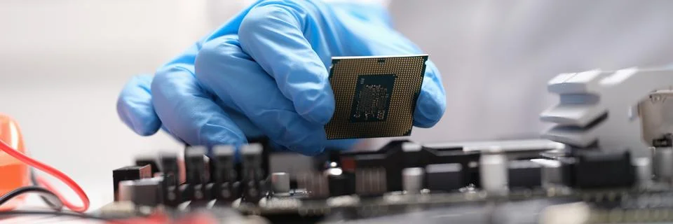 Technician connects a CPU microprocessor to motherboard socket Stockfoto's