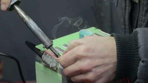 Technician connects electrical wires to a compact battery pack by hand Vidéo 344642948