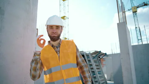 Technician contractor in hardhat helmet showing ok gesture construction site Stock Footage 258671395