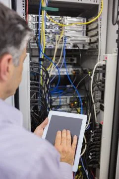 Technician controlling the server with a digital tablet Stock Photos