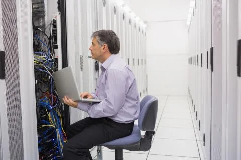Technician controlling the server with a laptop Stock Photos