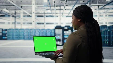 Technician in data center uses green screen laptop to deploy server architecture Stock Photos