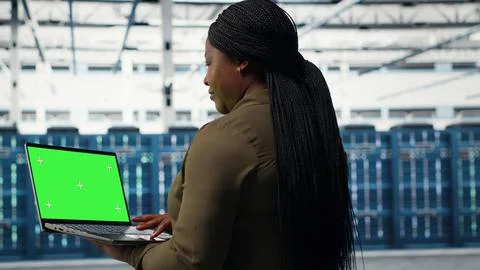 Technician in data center uses green screen laptop to deploy server architecture Stock Photos