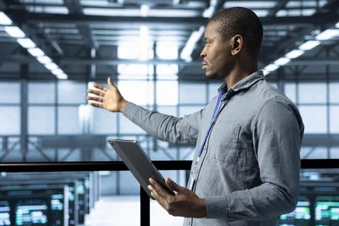 Technician in data center using tablet, developing disaster recovery plans Stock Photos