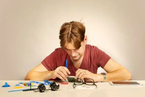 Technician disassembling smartphone with zoom camera lens to fix it Stock Photos