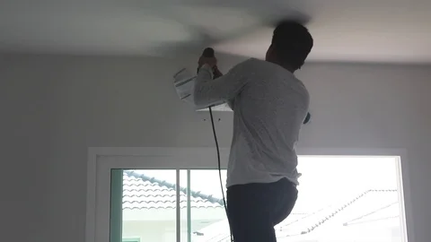 Technician drilling a hole in a wall to install an air conditioner Stock Footage 98451217