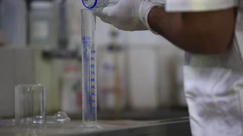 Technician dropping liquid into the measuring jar for the lab testing. Stock Footage 302138588