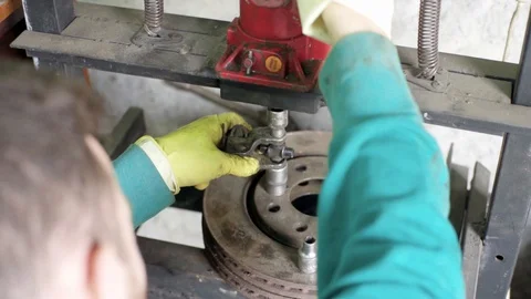 Technician during process of universal joint repair using hydraulic press Stock Footage 128921561