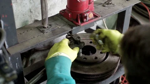 Technician during process of universal joint repair using hydraulic press Stock Footage 128921779