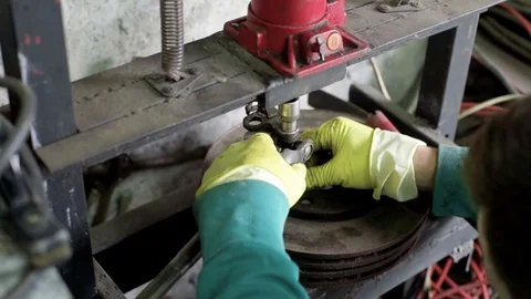 Technician during process of universal joint repair using hydraulic press Stock Footage 128921929