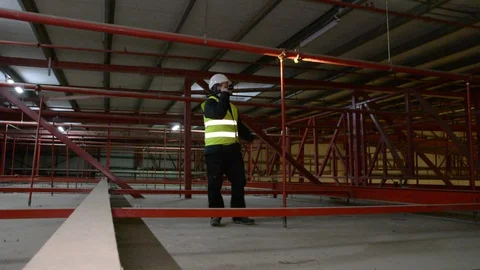 Technician engineer in a helmet checks the sprinklers pipes and roof constractio Stock Footage 102933246