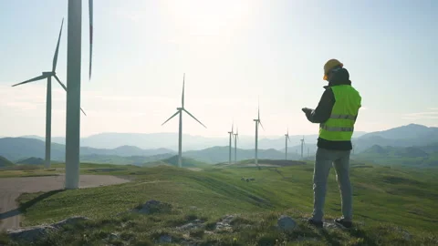 Technician Engineer in Wind Turbine Power Generator Station standing with a Stock Footage 131320801