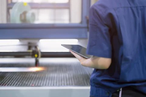 Technician engineer worker with Metal Laser cutting machine in modern steel.. Stock Photos