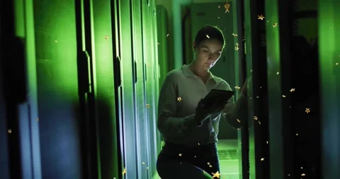 Technician entering green-lit server corridor, reviewing data on tablet with Stock Footage 329167325