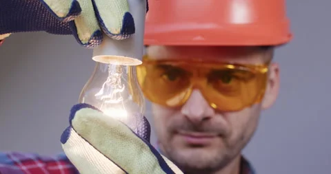 Technician examining light bulb finds item in working order Stock Footage 258070944